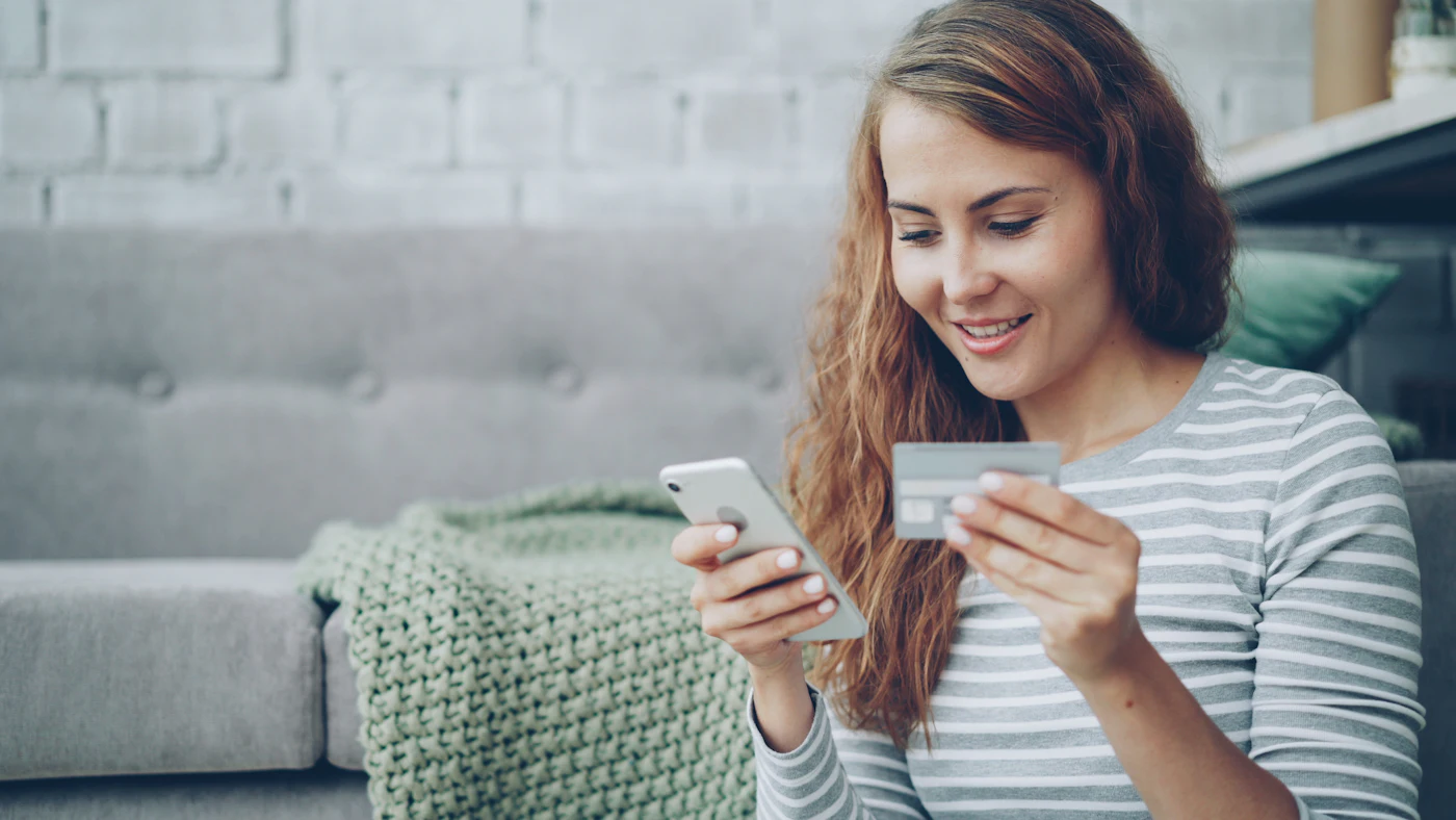 Frau kauft mit Smartphone und Kreditkarte online ein