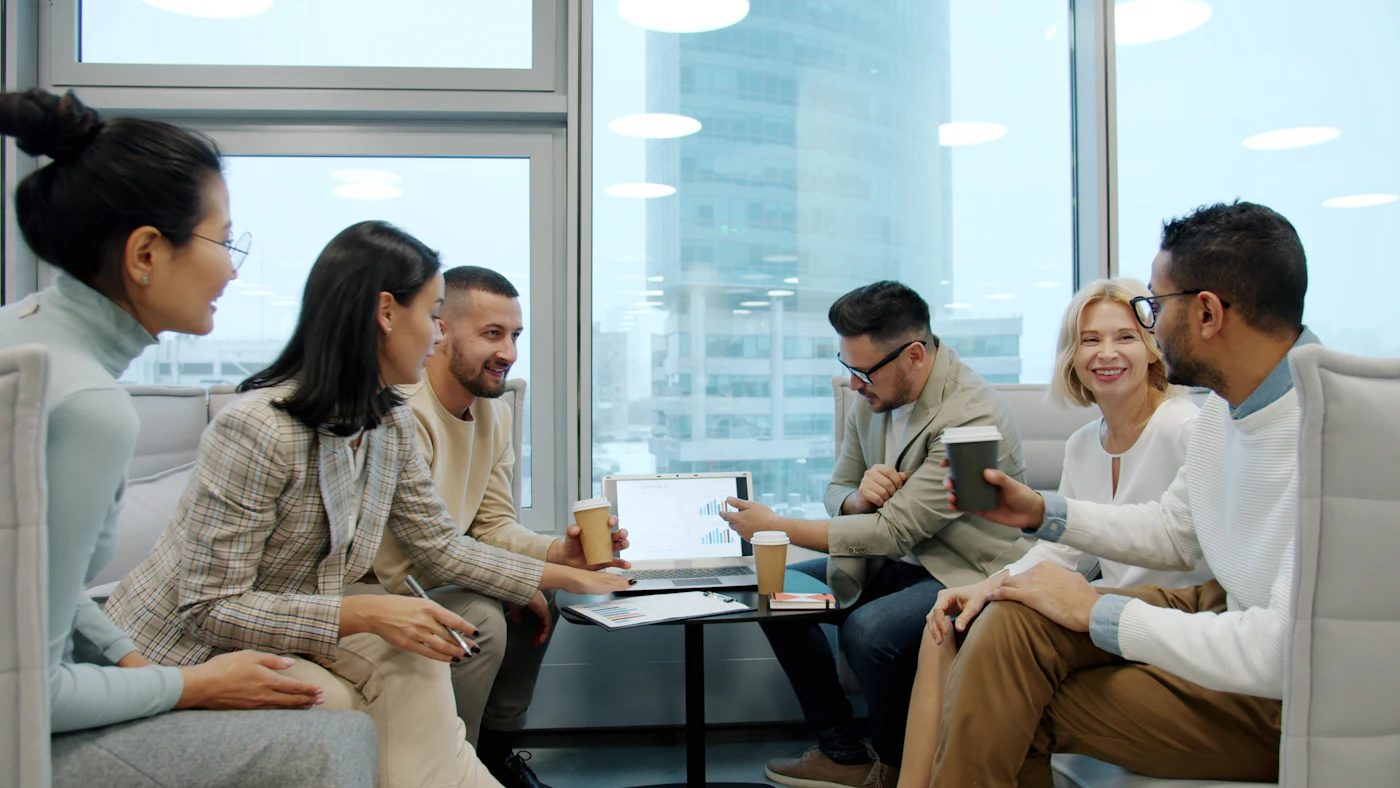 Equipo comentando informes juntos frente a un portátil